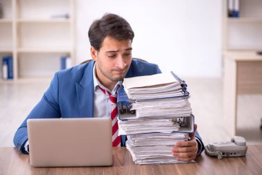 Genç işadamı işyerinde oturuyor.