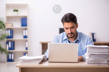 Genç işadamı ve işyerinde çok fazla iş var.