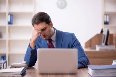 Genç işadamı işyerinde aşırı çalışmaktan memnun değil.