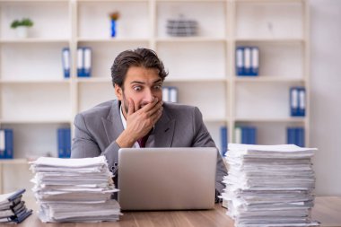 Genç işadamı ve ofiste çok fazla iş var.