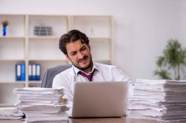 Genç işadamı ve ofiste çok fazla iş var.