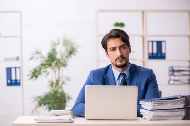 Genç bir çalışan ve ofiste çok fazla iş var.