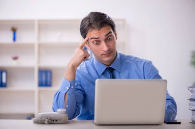 Genç işadamı ve işyerinde çok fazla iş var.