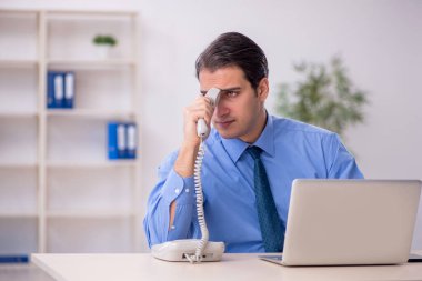 Genç işadamı ve işyerinde çok fazla iş var.