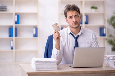 Genç işadamı ve ofiste çok fazla iş var.