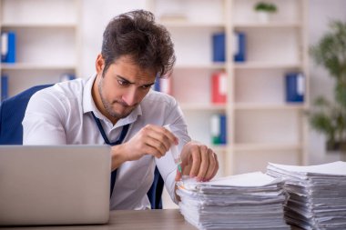 Genç işadamı ve ofiste çok fazla iş var.