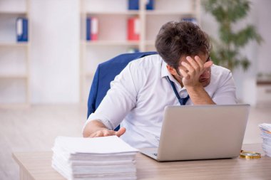 Genç işadamı ve ofiste çok fazla iş var.