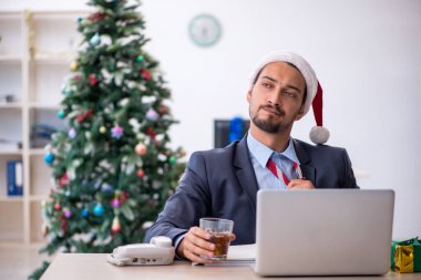 Genç çalışan Noel 'i ofiste kutluyor.