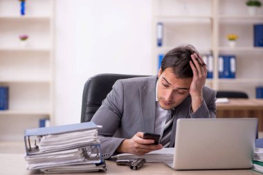 Ofisteki aşırı işten memnun olmayan genç bir çalışan.