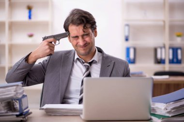 Ofisteki aşırı işten memnun olmayan genç bir çalışan.