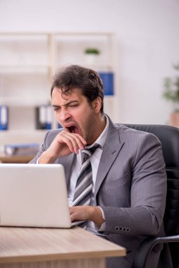 Ofisteki aşırı işten memnun olmayan genç bir çalışan.