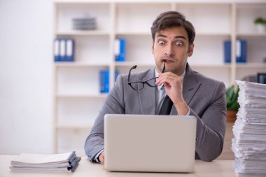 Genç işadamı ve ofiste çok fazla iş var.