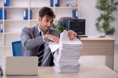 Genç işadamı ve ofiste çok fazla iş var.