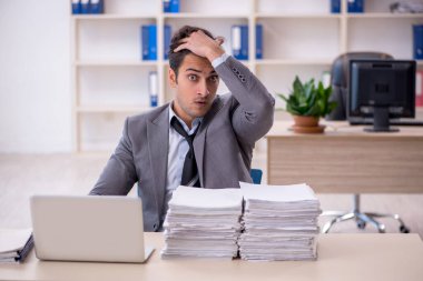 Genç işadamı ve ofiste çok fazla iş var.