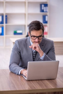 Ofisteki aşırı işten memnun olmayan genç bir çalışan.