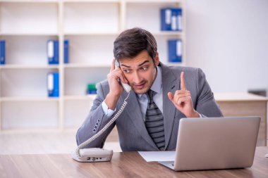 Ofisteki aşırı işten memnun olmayan genç bir çalışan.