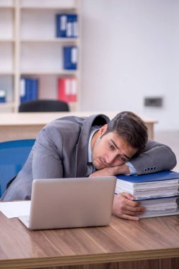 Ofisteki aşırı işten memnun olmayan genç bir çalışan.