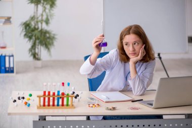 Laboratuvarda çalışan genç bir kimyager kız.