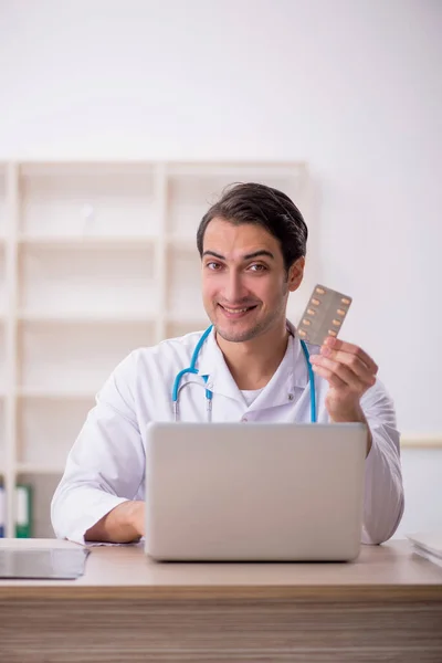 若い男性医師は クリニックで薬を提案します — ストック写真