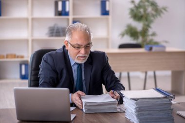 Ofiste çalışan eski bir işadamı.