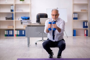 Eski erkek çalışanın teneffüste spor egzersizleri yapıyor.