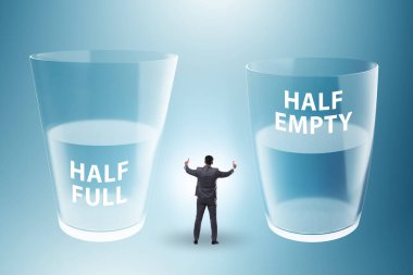 Businessman in the half empty half full glass concept clipart