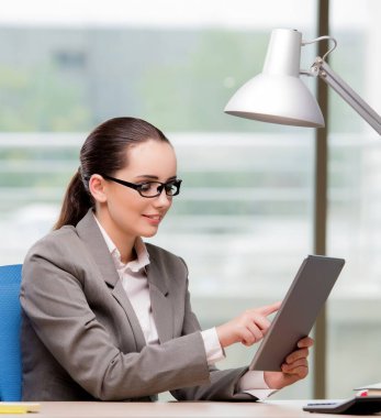 Tablet bilgisayarda çalışan iş kadını.