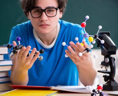 Sınıftaki genç erkek öğrenci.