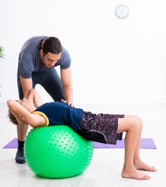 Genç baba ve oğlu egzersiz yapıyor.