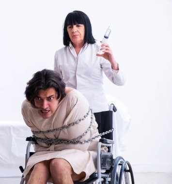 Yaşlı kadın psikiyatrist genç erkek hastayı ziyaret ediyor.