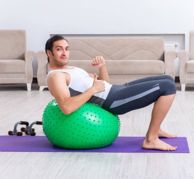 Genç adam evde antrenman ve egzersiz yapıyor.