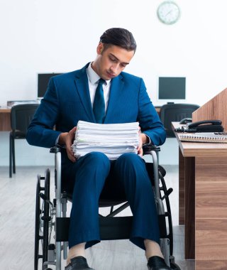 Tekerlekli sandalyedeki genç erkek çalışan.