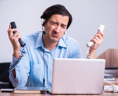 Masasında çalışan çağrı merkezi operatörü.