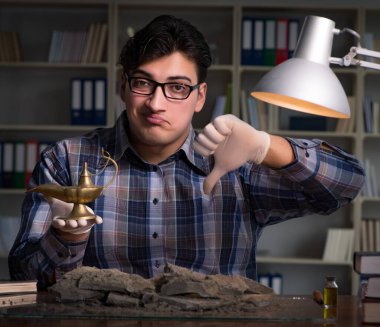 Arkeolog gece geç saatlere kadar ofiste çalışıyor.