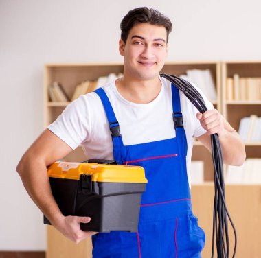 Evde elektrik tamiratı yapan adam.