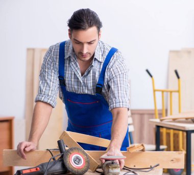 İçeride çalışan genç erkek marangoz.