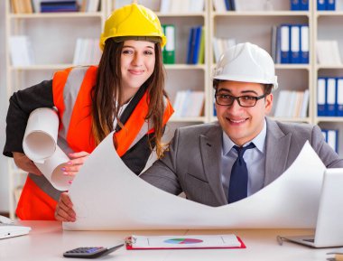 İnşaat ustabaşı çizimleri gözden geçiriyor.