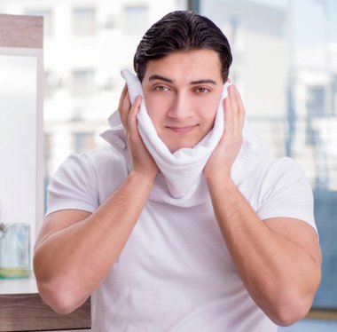 Yüz kremi süren genç yakışıklı adam.