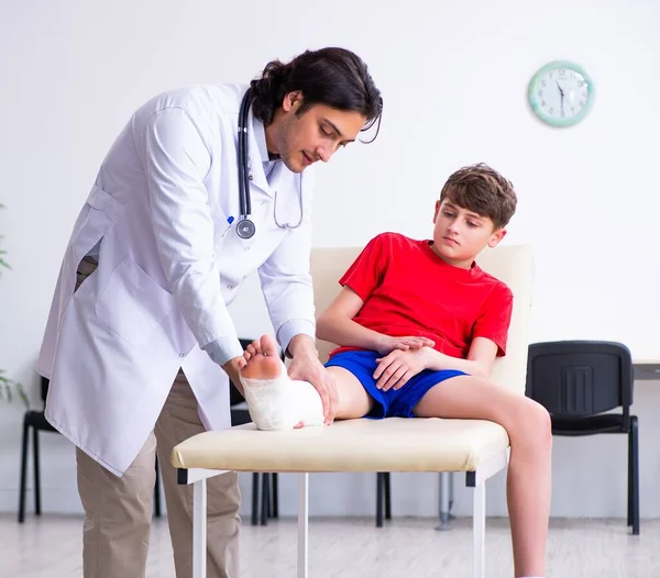 Der Bein Verletzte Junge Besucht Einen Jungen Arzt — Stockfoto