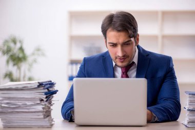 Genç işadamı ve işyerinde çok fazla iş var.