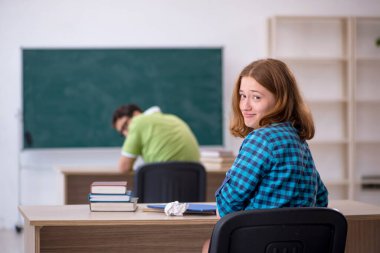 Ders sırasında iki öğrenci eğleniyor.