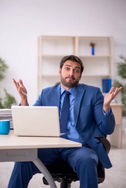 Genç işadamı ve işyerinde çok fazla iş var.