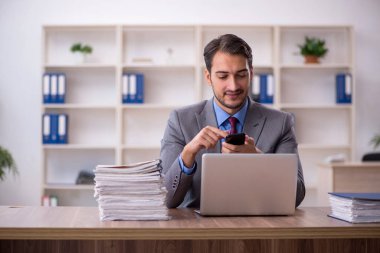 Genç işadamı işyerinde oturuyor.