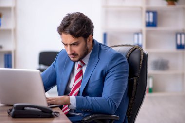 Genç işadamı ve işyerinde çok fazla iş var.