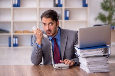 Genç işadamı işyerinde oturuyor.