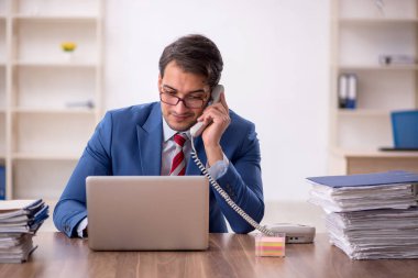 Genç işadamı işyerinde oturuyor.