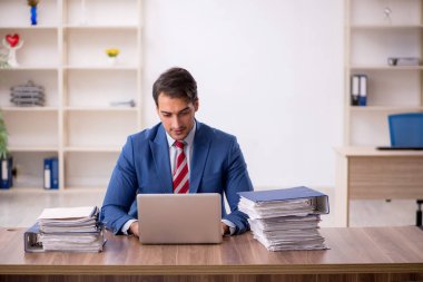 Genç işadamı işyerinde oturuyor.