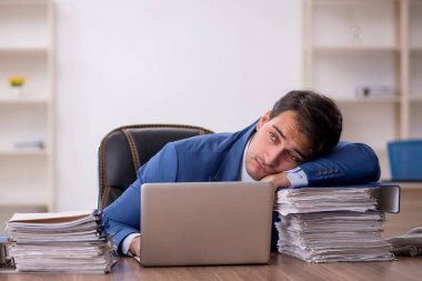 Genç işadamı işyerinde oturuyor.