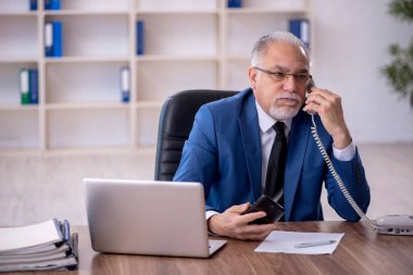 Ofiste çalışan eski bir işadamı.