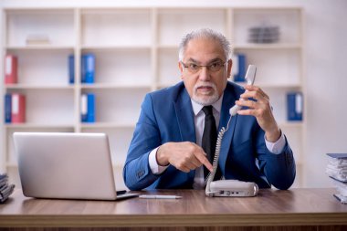 Ofiste çalışan eski bir işadamı.